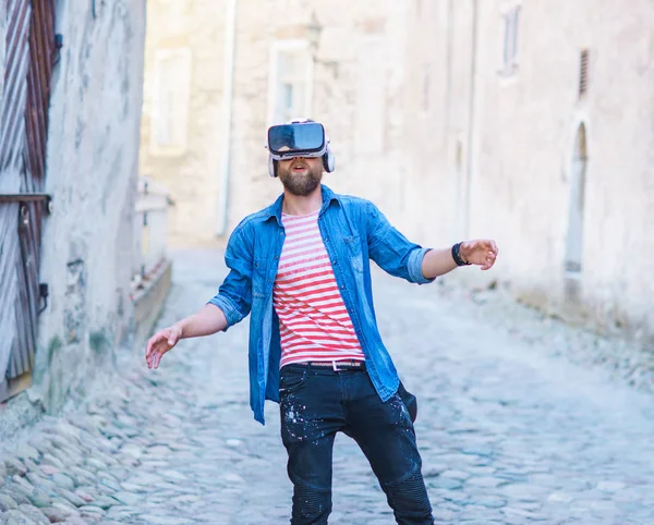 Man walking in the street in augmented or virtual reality headset. VR, AR, entertainment devices and futuristic technology concept.