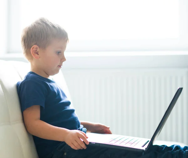 Portrait of happy boy playing with computer. Attractive kid with a laptop at home. Entertainment technology, futuristic gadgets and generation Z concept. — Stock Photo, Image