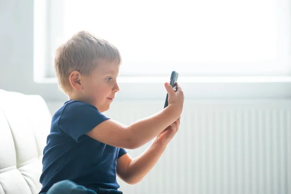 Bir smartphone ile oynamak mutlu çocuk portresi. Bir cep telefonu ile evde çocuk. Eğlence teknoloji, fütüristik gadget'lar, internet ve nesil Z kavramı. — Stok fotoğraf