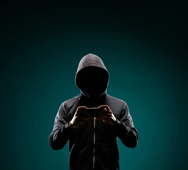 パーカーのコンピュータ ハッカーの肖像画 隠された暗い顔 データ泥棒 インターネット詐欺 ダークネットとサイバー セキュリティの概念 — ストック写真
