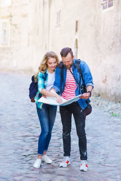 年轻的旅行者通过旅游地图浏览路线 有假期的男人和女人 背包客 旅游和旅游理念 — 图库照片