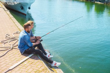 Adam kız arkadaşına balıkçılık öğretme. Harbor çubuk ile bir kaç. Tarih, aşk ve hobi kavramı.