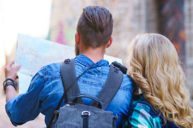Genç gezginler yön bir turist haritası ile keşfetmek. Erkek ve kadın tatil sahip. Backpackers, seyahat ve Turizm kavramı.