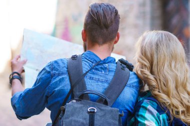 Genç gezginler yön bir turist haritası ile keşfetmek. Erkek ve kadın tatil sahip. Backpackers, seyahat ve Turizm kavramı.
