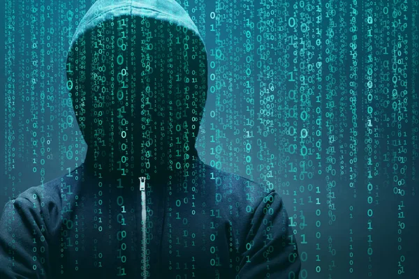 Anonymous computer hacker over abstract digital background. Obscured dark face in mask and hood. Data thief, internet attack, darknet fraud, dangerous viruses and cyber security concept.