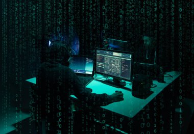 Aranan hackerlar virüs fidye yazılımını bodrumdaki bilgisayar ve dizüstü bilgisayarlarla kodluyorlar. Siber saldırı, sistem kırma ve kötü amaçlı yazılım kavramı.