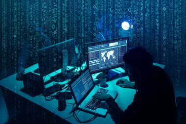 Aranan hackerlar virüs fidye yazılımını bodrumdaki bilgisayar ve dizüstü bilgisayarlarla kodluyorlar. Siber saldırı, sistem kırma ve kötü amaçlı yazılım kavramı.