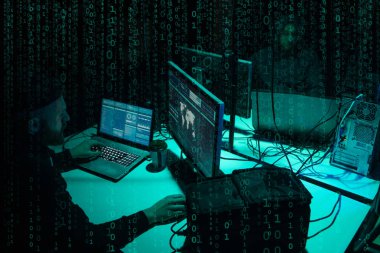 Aranan hackerlar virüs fidye yazılımını bodrumdaki bilgisayar ve dizüstü bilgisayarlarla kodluyorlar. Siber saldırı, sistem kırma ve kötü amaçlı yazılım kavramı.