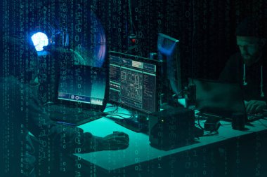 Aranan hackerlar virüs fidye yazılımını bodrumdaki bilgisayar ve dizüstü bilgisayarlarla kodluyorlar. Siber saldırı, sistem kırma ve kötü amaçlı yazılım kavramı.