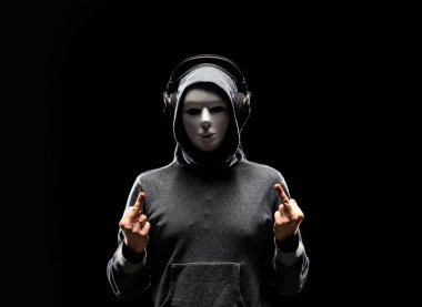 Bilgisayar korsanı beyaz maske ve kapüşonlu portresi. Gizlenmiş karanlık yüzü. Veri hırsız, internet dolandırıcılık, darknet ve siber güvenlik kavramı.