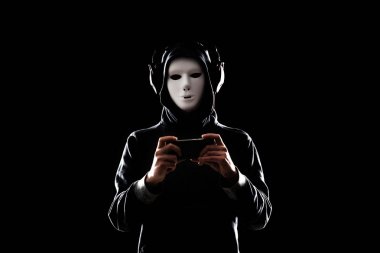 Bilgisayar korsanı beyaz maske ve kapüşonlu portresi. Gizlenmiş karanlık yüzü. Veri hırsız, internet dolandırıcılık, darknet ve siber güvenlik kavramı.