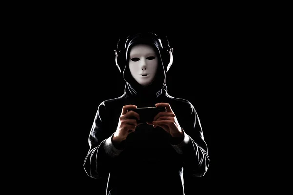 Portrait of computer hacker in white mask and hoodie. Obscured dark face. Data thief, internet fraud, darknet and cyber security concept.