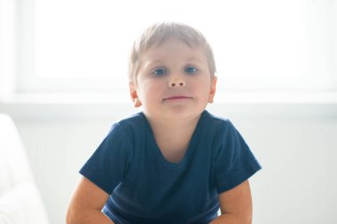 Mutlu gülümseyen çocuk portresi. Çekici çocuk evde. Gün ışığı. Nesil Z kavramı.