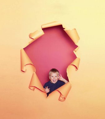 Sevimli gülümseyen bir çocuğun stüdyo portresi. Mutlu çocuk. Kağıt arka plan.