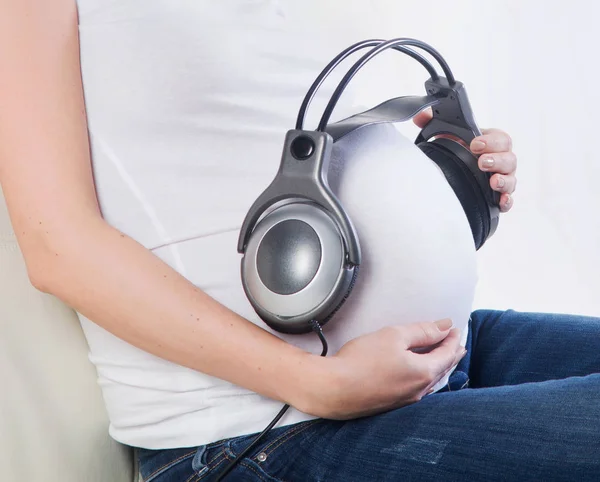 Close Mãe Grávida Dando Seu Bebê Para Ouvir Música — Fotografia de Stock