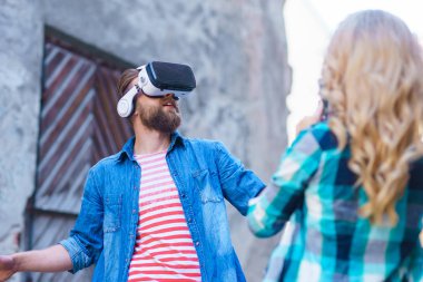 Artar veya sanal gerçeklik kulaklık sokakta yürüyen bir çift. VR, Ar, eğlence cihazları ve fütüristik teknoloji kavramı.