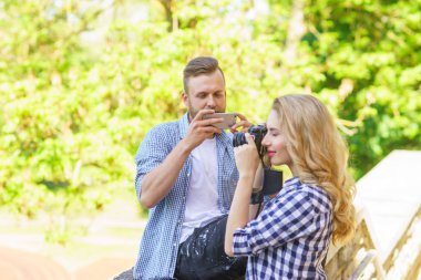 Erkek ve kadın bir kamera ve bir akıllı telefon ile fotoğraf çekmek. Aşk ve ilişkiler seyahat kavramı.