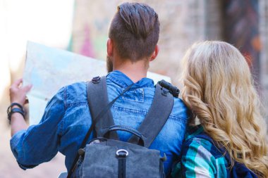 Genç gezginler yön bir turist haritası ile keşfetmek. Erkek ve kadın tatil sahip. Backpackers, seyahat ve Turizm kavramı.
