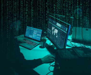 Aranan hackerlar virüs fidye yazılımını bodrumdaki bilgisayar ve dizüstü bilgisayarlarla kodluyorlar. Siber saldırı, sistem kırma ve kötü amaçlı yazılım kavramı.