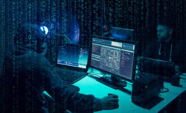 Aranan hackerlar virüs fidye yazılımını bodrumdaki bilgisayar ve dizüstü bilgisayarlarla kodluyorlar. Siber saldırı, sistem kırma ve kötü amaçlı yazılım kavramı.