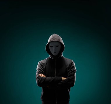 Bilgisayar korsanı beyaz maske ve kapüşonlu portresi. Gizlenmiş karanlık yüzü. Veri hırsız, internet dolandırıcılık, darknet ve siber güvenlik kavramı.