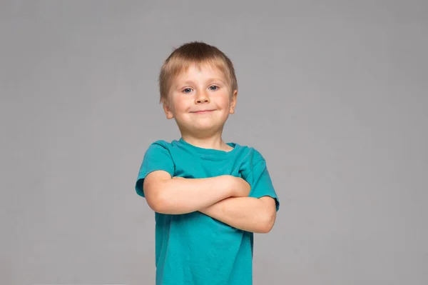 Egy boldog mosolygó fiú portréja kék póló. Attraktív gyerek a stúdióban. — Stock Fotó