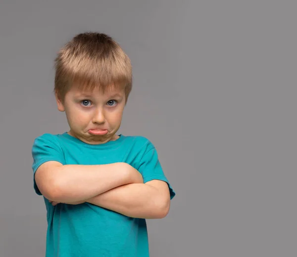 Un chico ofendido con camiseta azul. Chico triste y molesto en el estudio. Concepto de infancia . —  Fotos de Stock