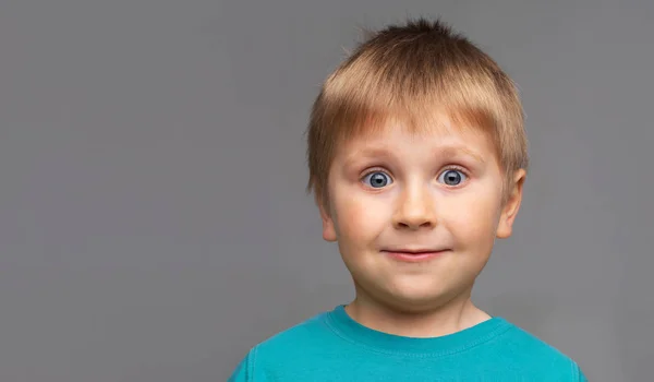 Porträt eines glücklich lächelnden Jungen im blauen T-Shirt. attraktives Kind im Atelier. — Stockfoto