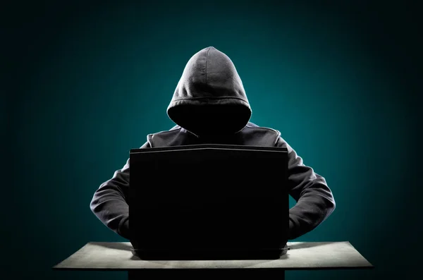 Computerhacker im Kapuzenpulli. verdunkeltes dunkles Gesicht. Datendieb, Internetbetrug, Darknet und Cyber-Sicherheitskonzept. — Stockfoto