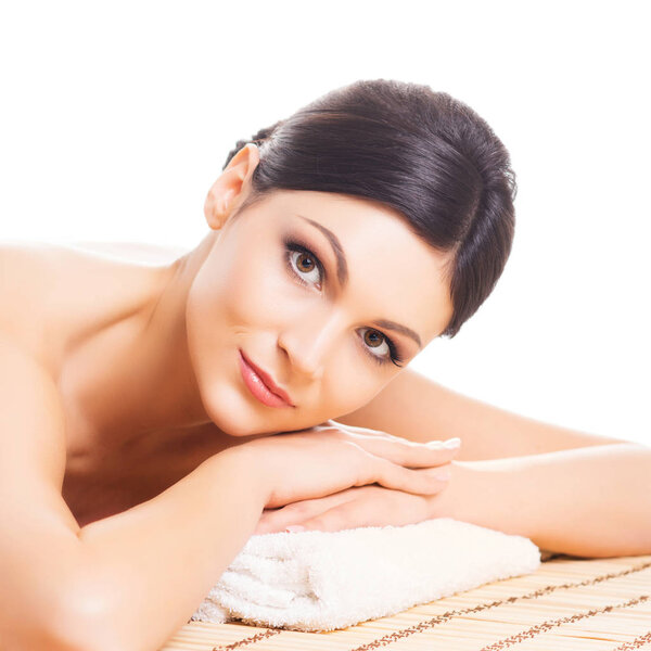 Beautiful, young and healthy woman in spa salon. Isolated on white. Spa, massage, health and healing concept.