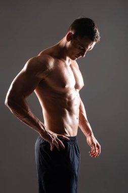 Siyah arka plan üzerinde güçlü, formda ve sporcu bir vücut geliştirici. Spor ve spor konsepti.