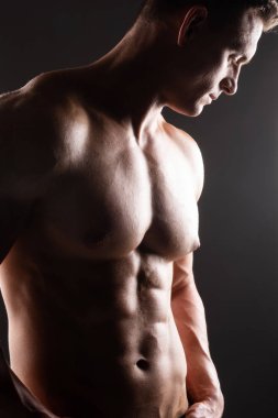 Siyah arka plan üzerinde güçlü, formda ve sporcu bir vücut geliştirici. Spor ve spor konsepti.