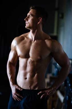 Siyah arka plan üzerinde güçlü, formda ve sporcu bir vücut geliştirici. Spor ve spor konsepti.