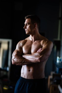 Siyah arka plan üzerinde güçlü, formda ve sporcu bir vücut geliştirici. Spor ve spor konsepti.