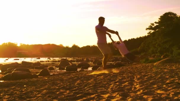 父亲在海边和他的儿子玩耍 日落或日出的温暖颜色 慈爱的父母和美丽的孩子 父子关系和亲子关系概念 — 图库视频影像