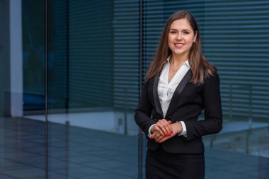 Modern ofis binasının önünde kendine güvenen bir iş kadını. İş, bankacılık, şirket, gayrimenkul ve finansal piyasa kavramı.