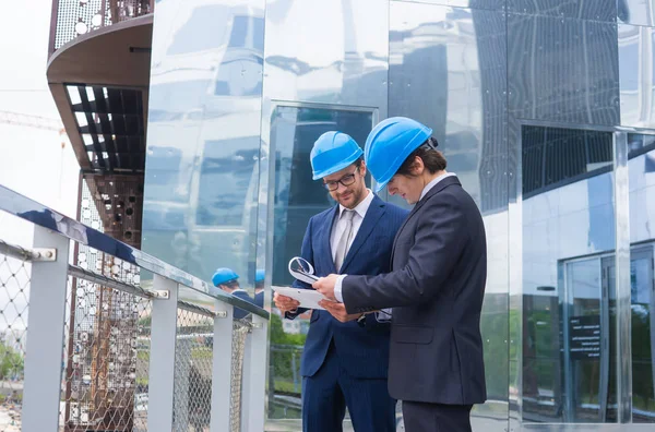 Immobilienentwickler Helmen Büroneubau Selbstbewusste Geschäftsleute Und Architekten Gespräch Vor Modernen — Stockfoto