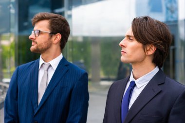 Kendine güvenen iş adamları modern ofis binasının önünde konuşuyorlar. İş adamı ve iş arkadaşı. Bankacılık ve finans piyasası kavramı.
