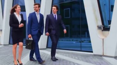 Modern ofis binasının önünde konuşan emin işadamlarının. İşadamlarının ve iş kadınının işi var. Bankacılık, profesyonel iş ve finansal piyasa konsepti.