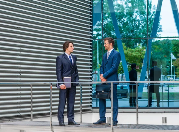 近代的なオフィスビルの前で話す自信のあるビジネスマン ビジネスマンとビジネスウーマンはビジネスの会話をします 専門職 金融市場の概念 — ストック写真