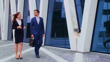 Modern ofis binasının önünde konuşan emin işadamlarının. İşadamlarının ve iş kadınının işi var. Bankacılık, profesyonel iş ve finansal piyasa konsepti.