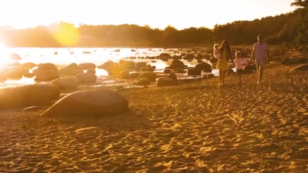 幸福的家庭在海边散步 海滩和海洋 日落或日出的温暖颜色 慈爱的父母和美丽的孩子 爱和父母的概念 — 图库视频影像
