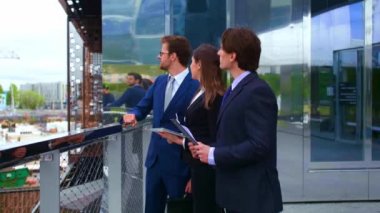 Modern ofis binasının önünde konuşan emin işadamlarının. İşadamlarının ve iş kadınının işi var. Bankacılık, profesyonel iş ve finansal piyasa konsepti.