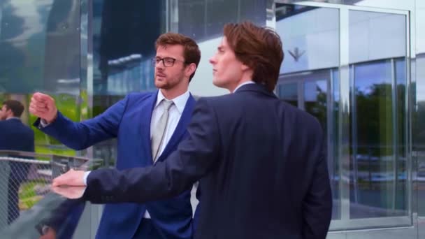 近代的なオフィスビルの前で話す自信のあるビジネスマン ビジネスマンと彼の同僚銀行と金融市場の概念 — ストック動画