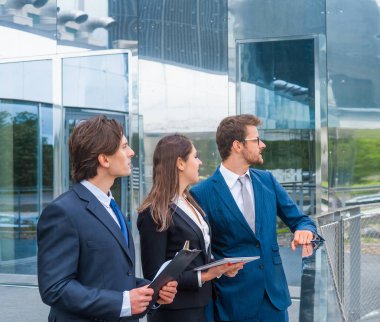 Modern ofis binasının önünde konuşan emin işadamlarının. İşadamlarının ve iş kadınının işi var. Bankacılık, profesyonel iş ve finansal piyasa konsepti.