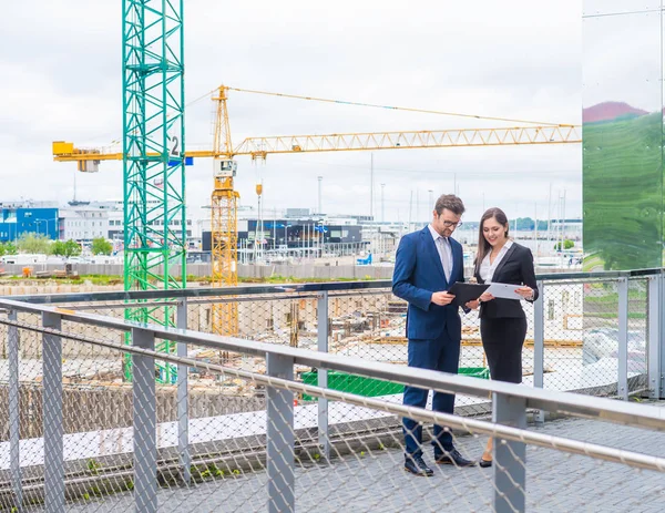 Selbstbewusste Geschäftsleute unterhalten sich vor modernen Bürogebäuden. Geschäftsfrau und Geschäftsfrau unterhalten sich. Banken, Beruf und Finanzmarkt. — Stockfoto