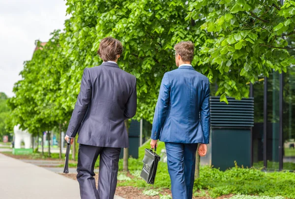 Selbstbewusste Geschäftsleute unterhalten sich vor modernen Bürogebäuden. Geschäftsmann und sein Kollege. Banken- und Finanzmarkt. — Stockfoto