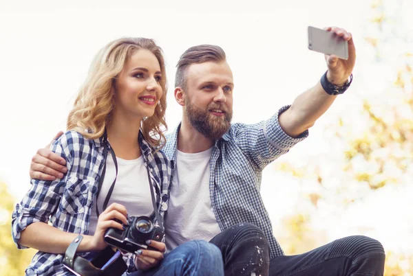 Jovem casal amoroso fazendo foto selfie no parque de outono . — Fotografia de Stock