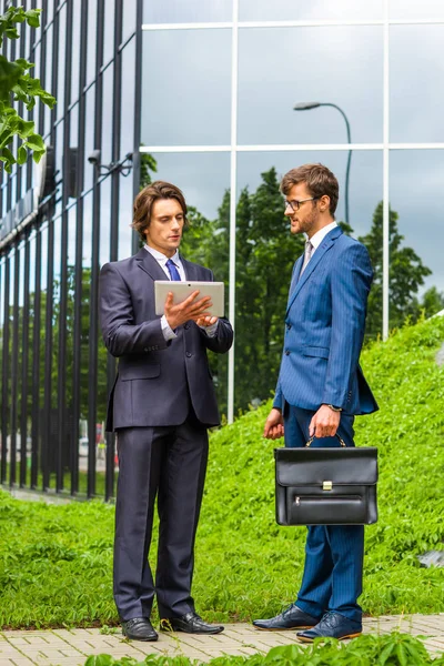 Hombres de negocios confiados hablando frente a un moderno edificio de oficinas. Empresario y su colega. Mercado bancario y financiero . — Foto de Stock