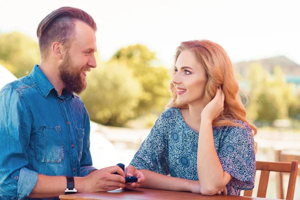 Cásate conmigo concepto. Una pareja encantadora comprometiéndose en un café al aire libre. Fondo de otoño . — Foto de Stock